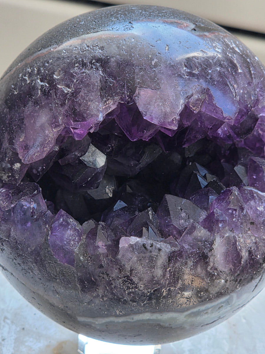 Deep purple Brazilian amethyst crystals inside a geode sphere