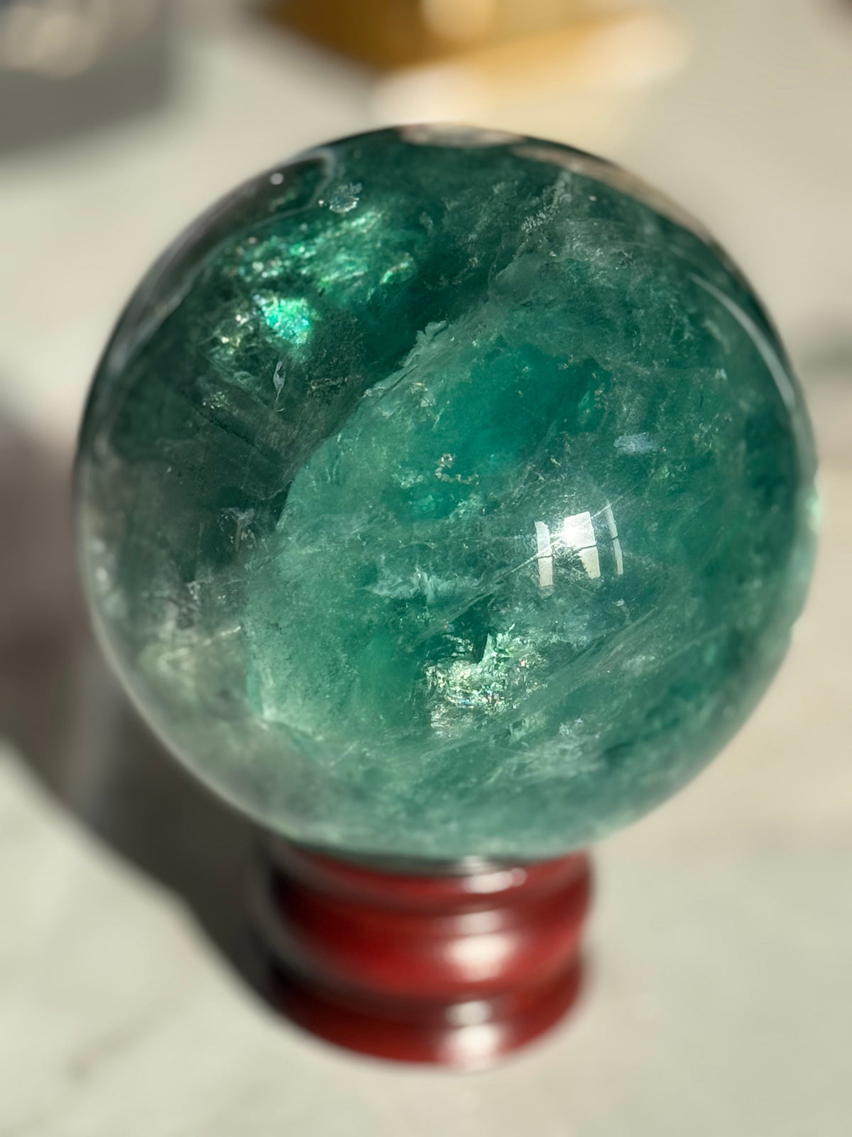 Natural green fluorite crystal sphere with teal and emerald banding
