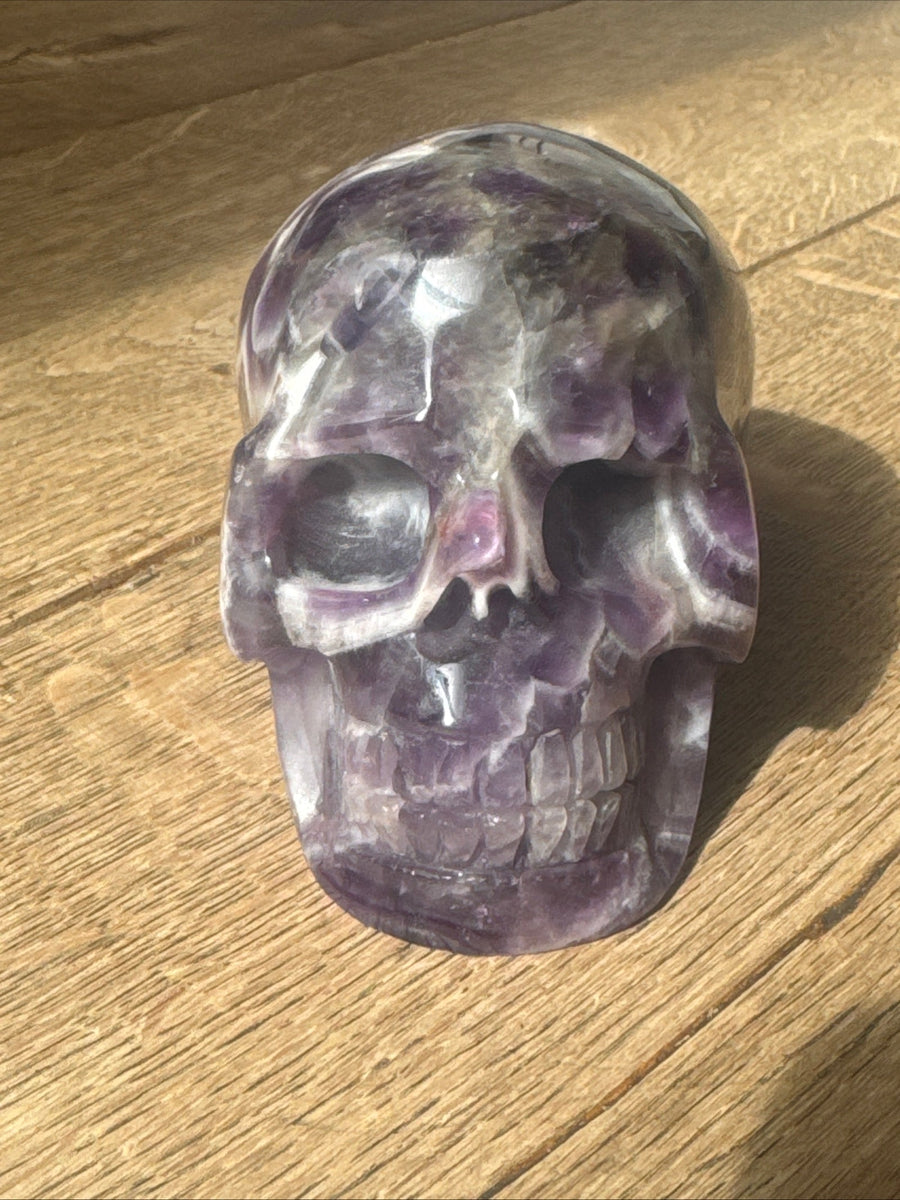 Hand-carved deep purple amethyst crystal skull with white veins