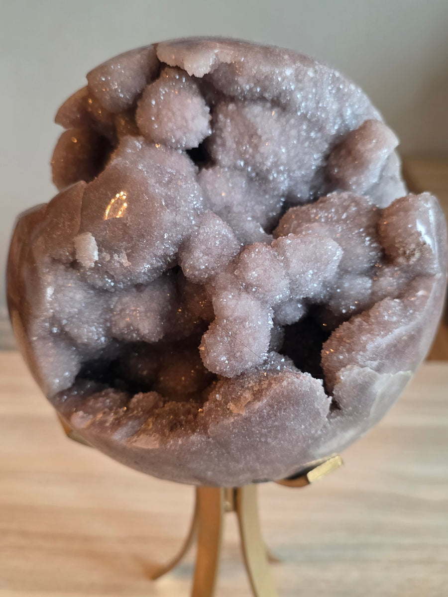 Large pink amethyst geode sphere 7.2kg, 19cm, on gold rotating stand – front view of crystal cave