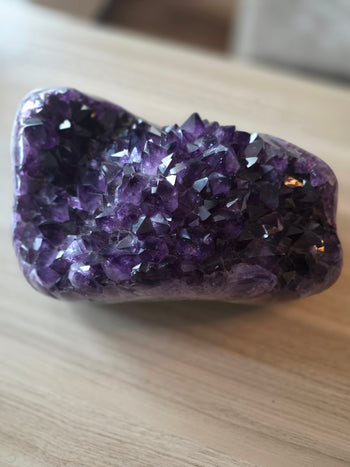 Three-quarter view of large Brazilian amethyst geode with glassy royal purple points