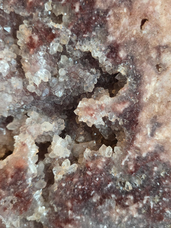 Crystal-lined pocket of clear quartz inside a pink amethyst slab