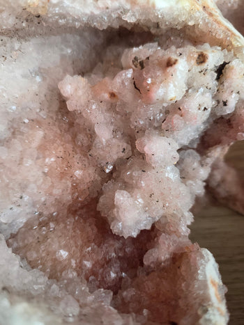 Close-up of pale pink snowball crystal clusters inside a pink amethyst geode
