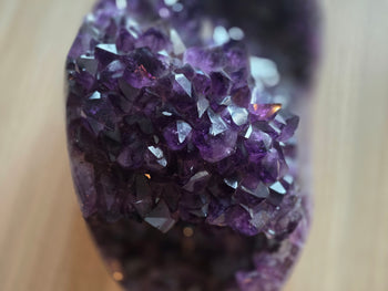 Close-up of sparkling dark plum amethyst crystals in a large geode cluster