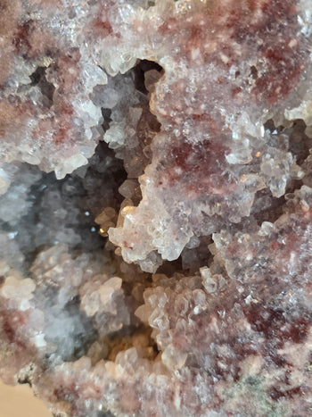 Deep crystal cave lined with quartz points in a pink amethyst geode slab