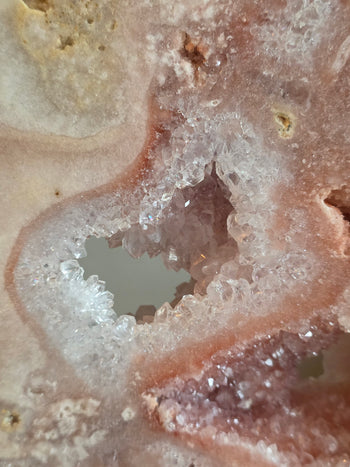 Clear quartz crystal points lining a see-through window in pink amethyst