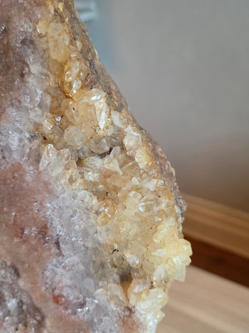 Honey-gold calcite crystals along the edge of a pink amethyst slab