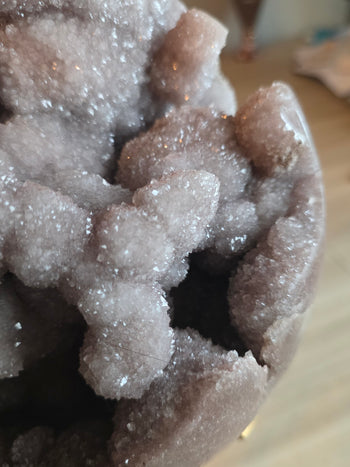 Glittering pink and lilac crystal points inside a geode sphere