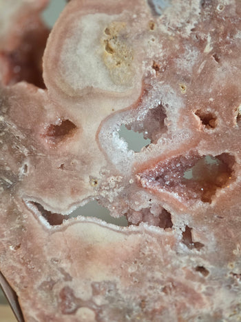 Crystal-lined pockets and white radiating sprays in a pink amethyst slab