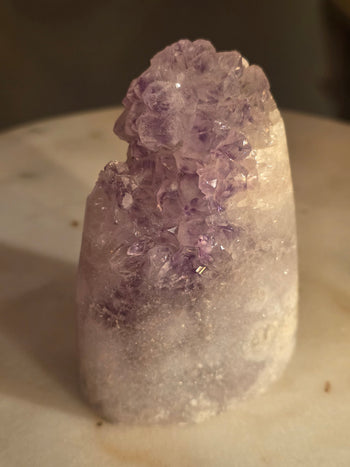 Lavender amethyst crystal cluster with violet phantoms on sparkling white quartz