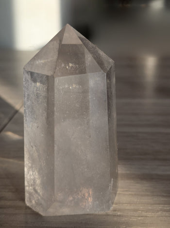 Clear quartz crystal tower 196g showing clear faces and misty veils, angled view