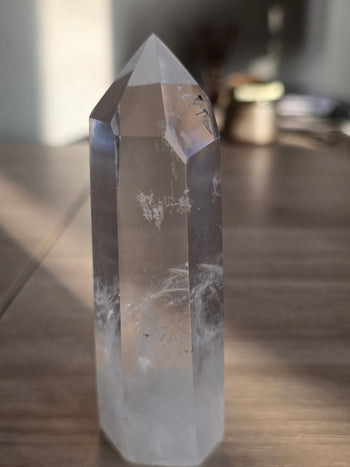 Clear quartz crystal point 182g with glassy faces, angled view