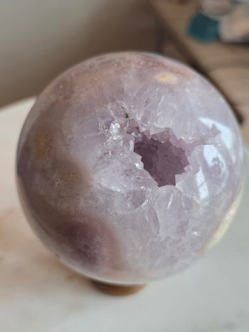 Pale lilac amethyst crystal pocket inside a polished geode sphere