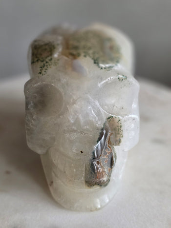 Face of moss agate crystal skull with translucent quartz and green moss inclusions