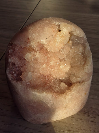 Close-up of peach-pink druzy crystals inside a natural pink amethyst geode