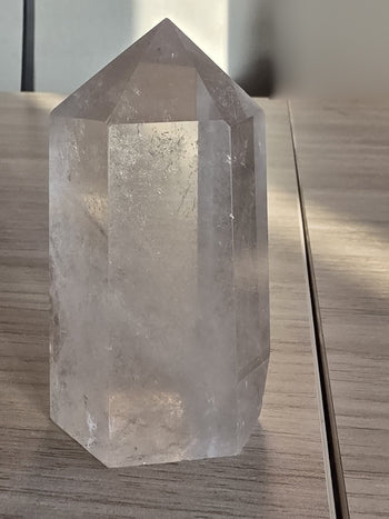 Polished clear quartz point 9cm, side view of six-sided tower