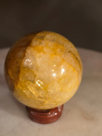 Side view of golden healer crystal ball showing golden bands through the quartz