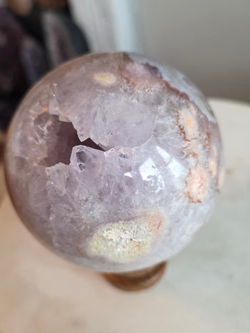 Angled view of lavender amethyst sphere with feathery white crystal growth