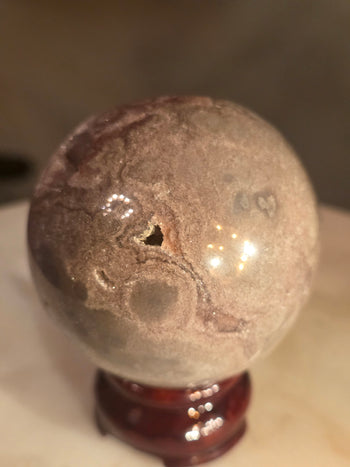 Top view into the pink amethyst geode cavity of a 6.7cm crystal sphere