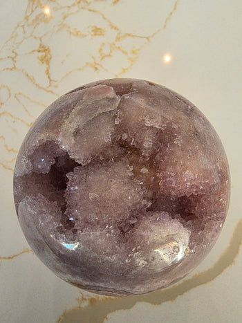 Close-up of the deep druzy cavity inside a pink amethyst geode sphere