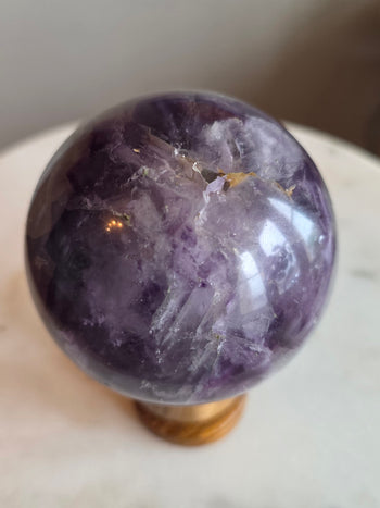 Top view of fluorite crystal ball showing violet bands and clear phantoms