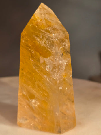 Close-up of golden healer quartz veils and inclusions inside the polished tower