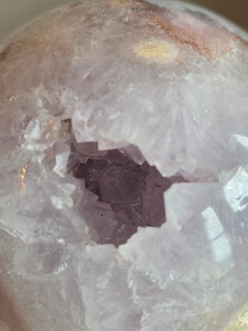 Close-up of sparkling lavender amethyst points inside the geode cavity