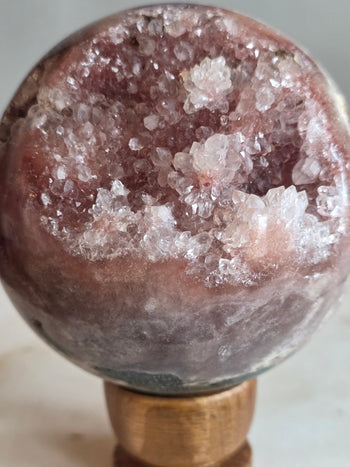Rose-pink and raspberry druzy cavity inside a natural pink amethyst sphere