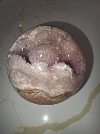 Natural agate banding along the edge of a pink amethyst geode sphere