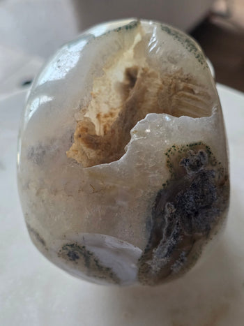 Back of 12cm moss agate skull carving showing natural geode and agate patterns