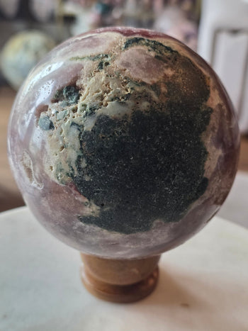 Back of pink amethyst geode sphere with lilac banding and green basalt patch
