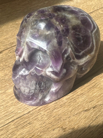 Amethyst crystal skull 805g showing natural white veining, angled view