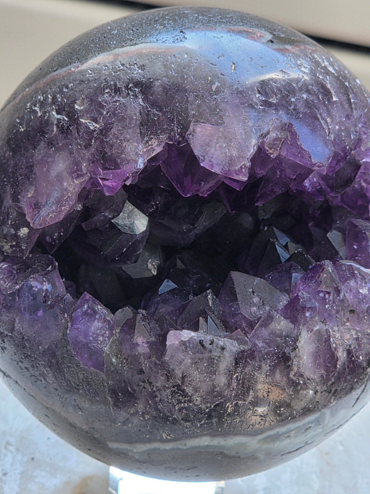 Amethyst geode sphere 925g from Brazil with deep purple druzy cavity, front view
