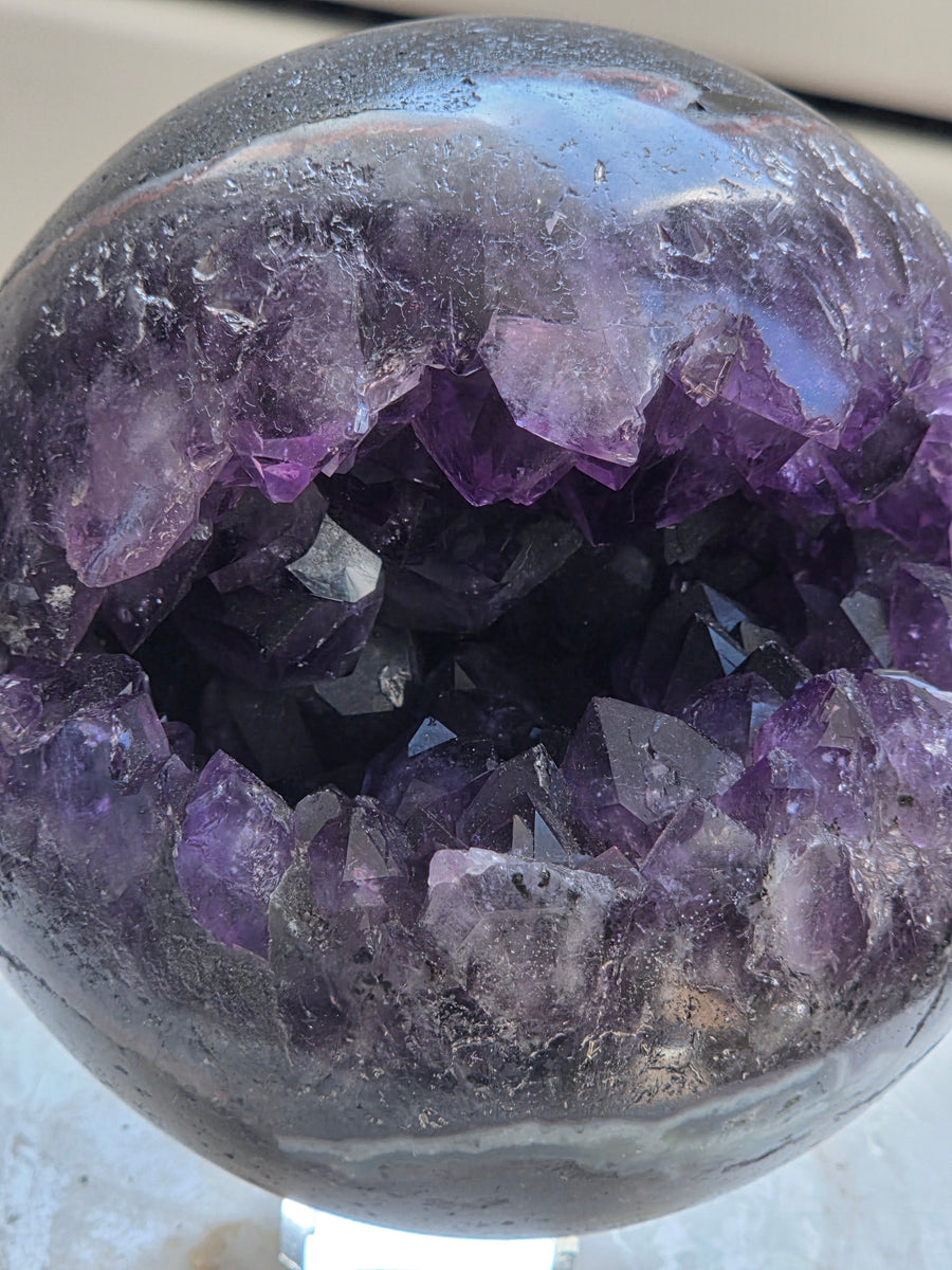 Amethyst geode sphere 925g from Brazil with deep purple druzy cavity, front view
