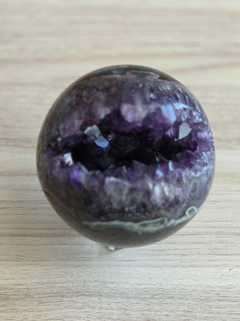 Natural amethyst geode sphere 925g, angled view of crystal cavity