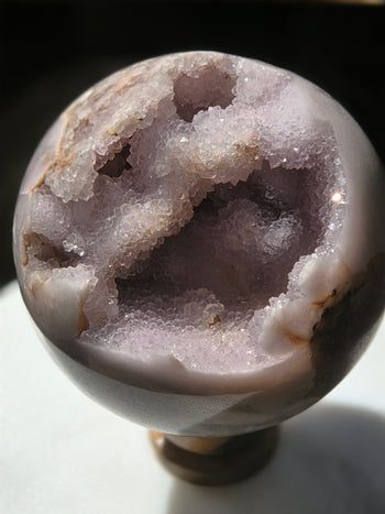 Close-up of pink and lilac druzy crystals in pink amethyst geode sphere