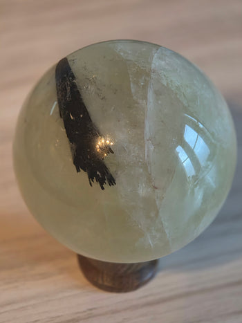 1.5kg citrine sphere with black tourmaline inclusion on wooden stand
