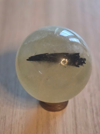 1.5kg citrine sphere with black tourmaline inclusion on wooden stand – view 2