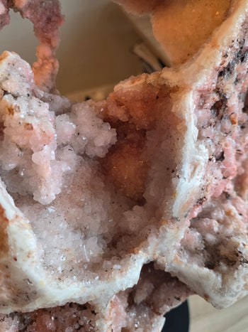 Lower crystal caves of a large pink amethyst geode on stand